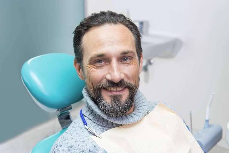 man sitting in a dental chair smiling